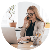 Businesswoman works on mobile phone and laptop computer