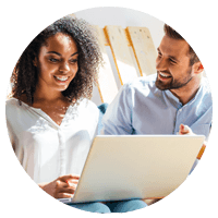 Smiling businessman and woman working on laptop computer