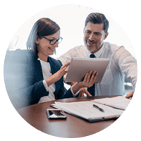 Two business professionals looking at tablet computer at desk