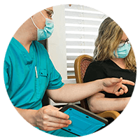 The nurse talking to the patient using a tablet