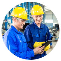 Two construction workers on tablet device in factory