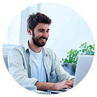 Man with beard smiling while working