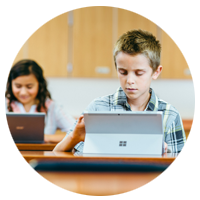 Elementary school aged children work on their Microsoft Surface and laptop computers