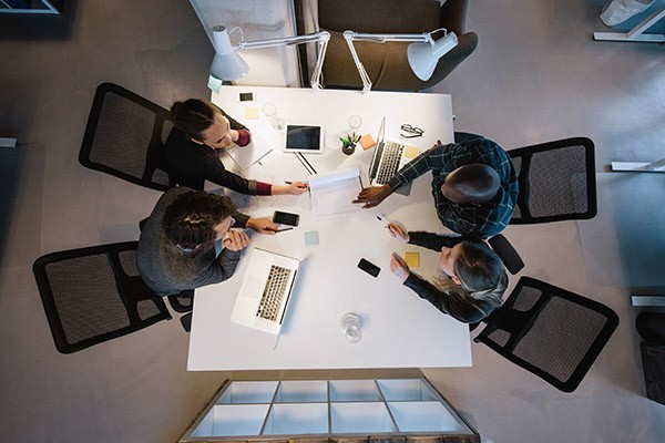 People collaborating at a table on laptops