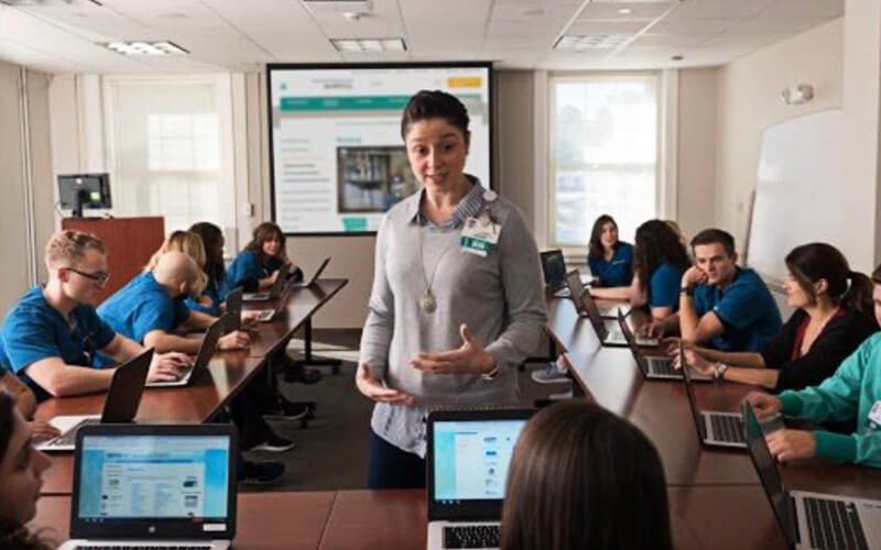 Professional discussing in front of students