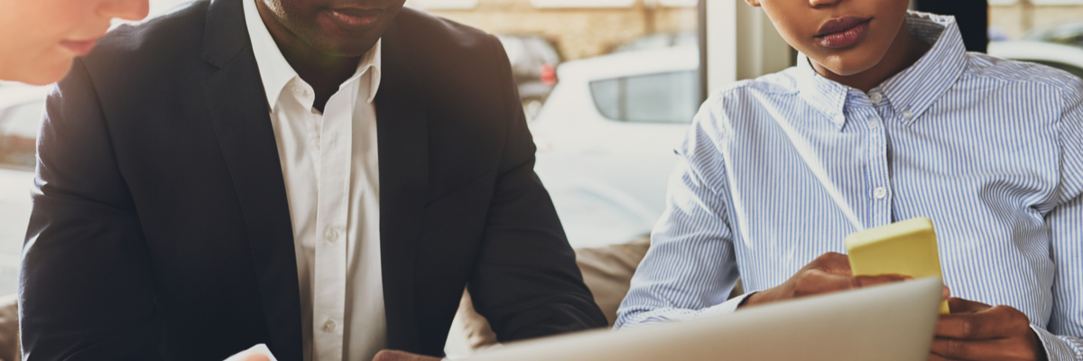 View of two business professionals collaborating around laptop