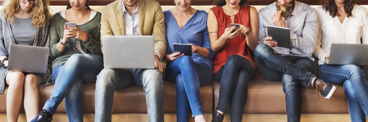 A group of people sitting on a bench in a BYOD workplace