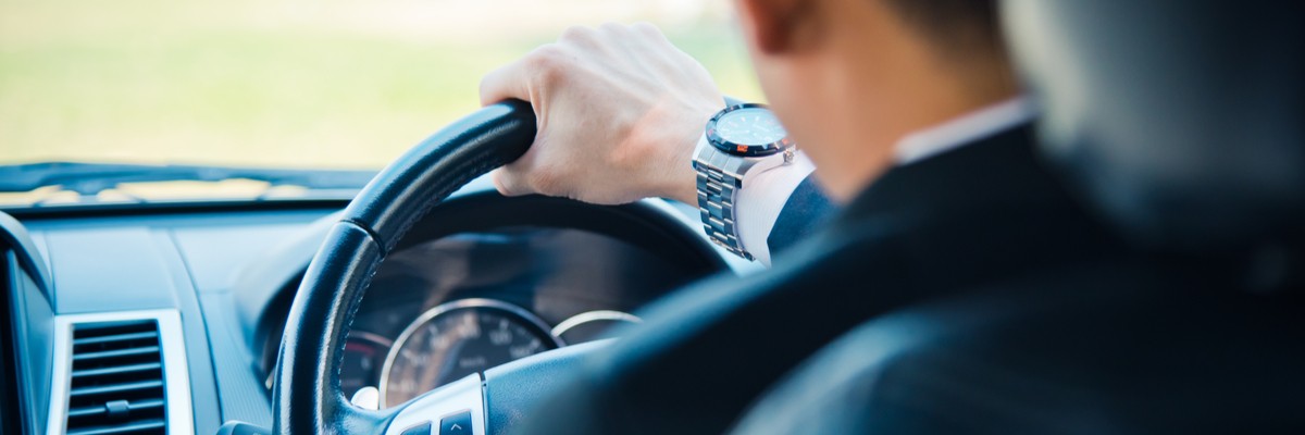 Business man behind the wheel of a car.