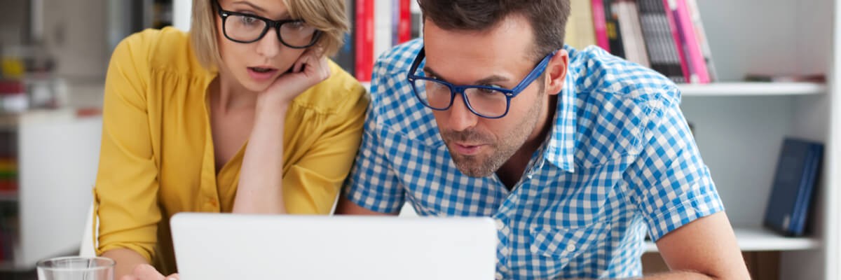 Man and woman looking at a laptop.