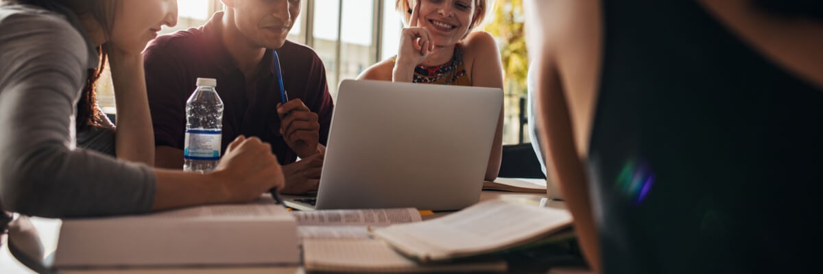 Man and women using laptop while sitting together