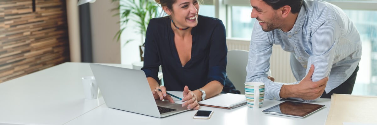 Two business people looking at a computer.