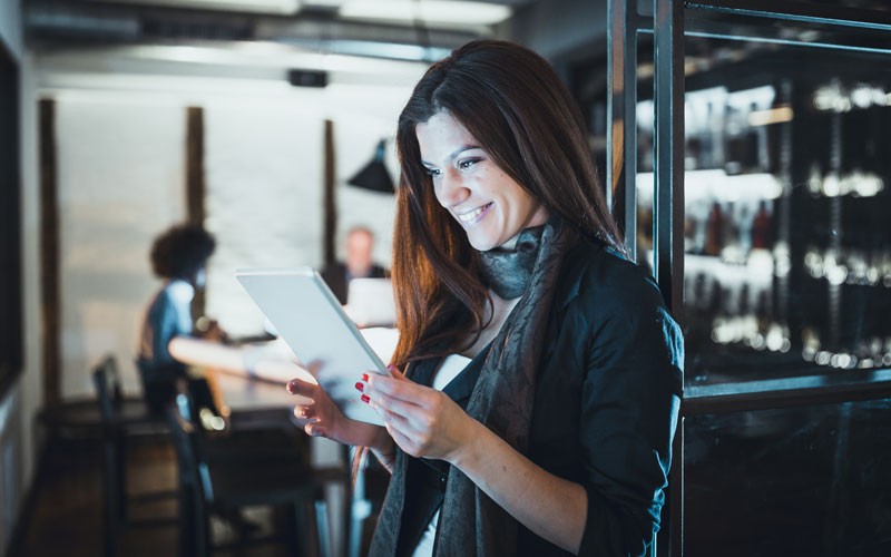 Woman smiling while reading analyst report