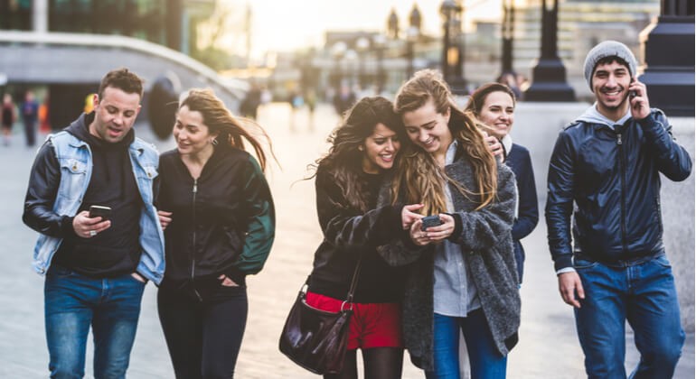 Group of friends walking and on mobile devices