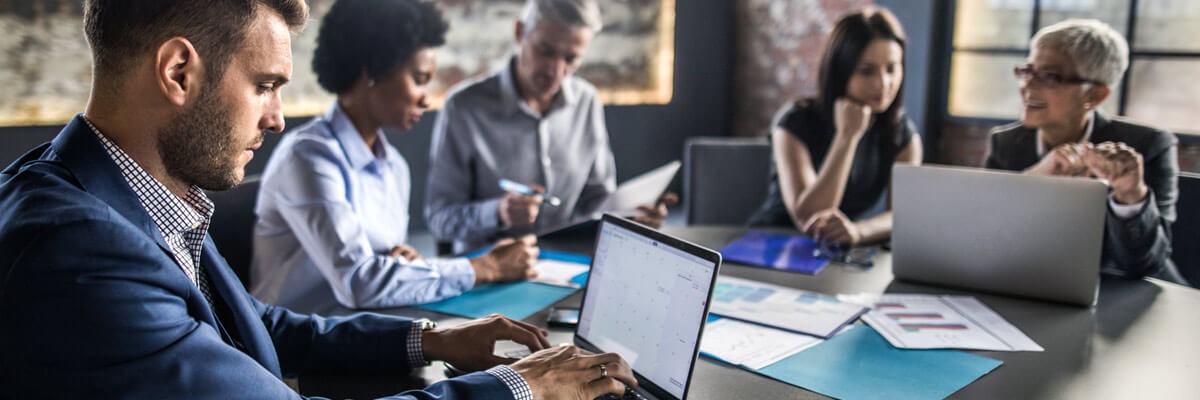 Business professionals using laptops in a modern office meeting