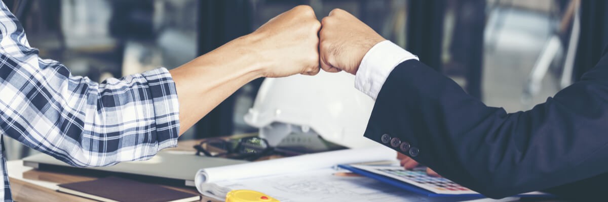 Close up of businessmen fist bumping while having a discussion