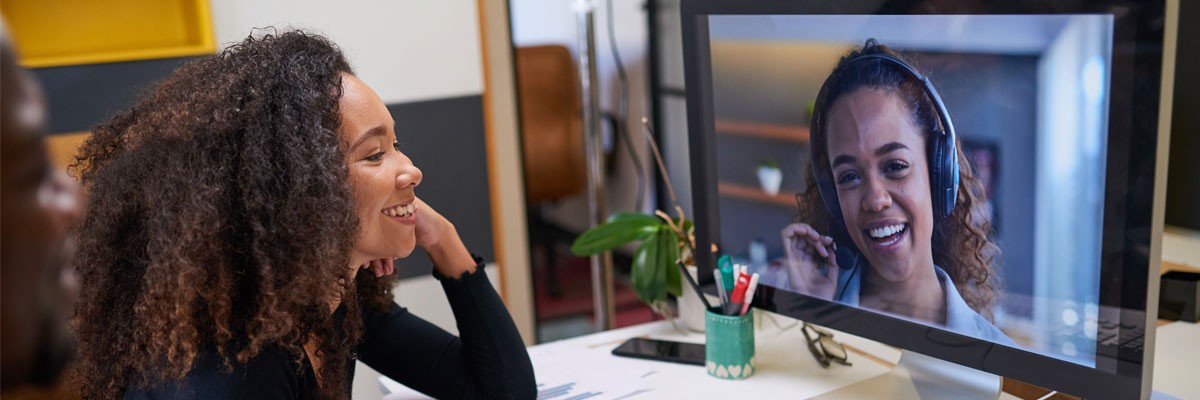 Hybrid workforce concept with woman on video call with remote teammate