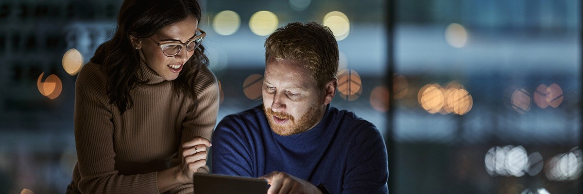 Users working at night in office on technology devices