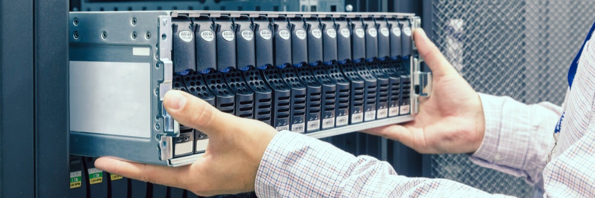 IT Engineer installs enclosure with hard disk drive in the storage system in the rack in datacenter