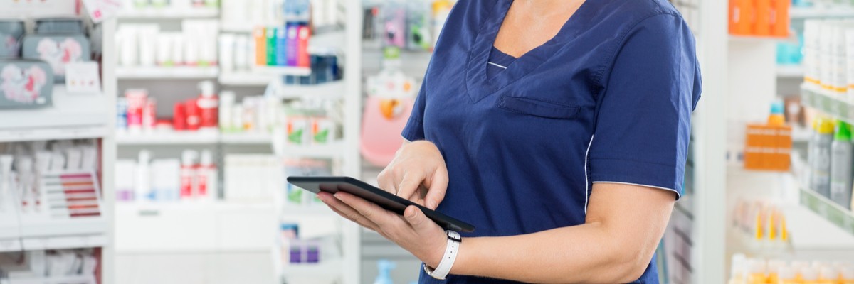 Photo of a nurse that is using a tablet in the medication room