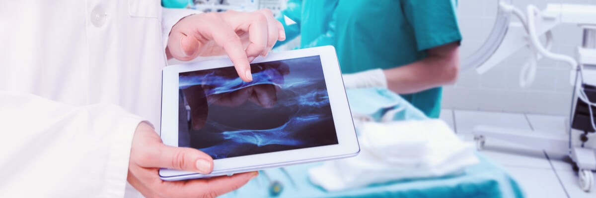 Tablet in doctors hands during a surgery