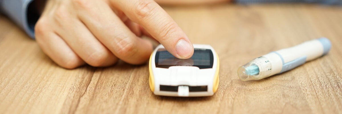 Elderly diabetic using a blood testing device