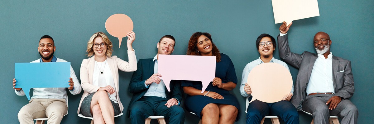 Business team holding up word balloons.