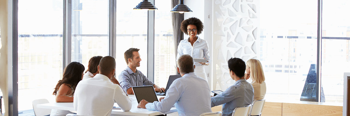 Group of business professionals gathered around in presentation meeting