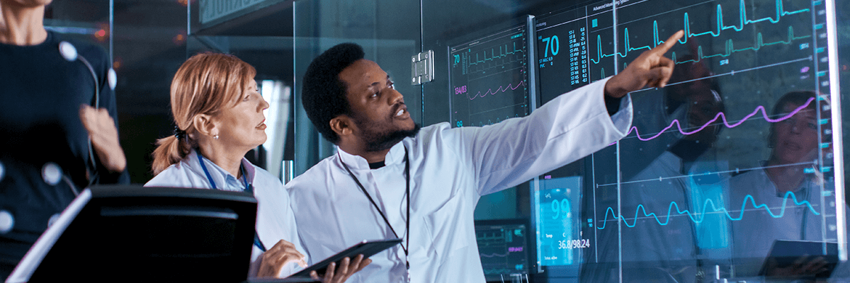 Healthcare technician pointing to stats displayed on digital display