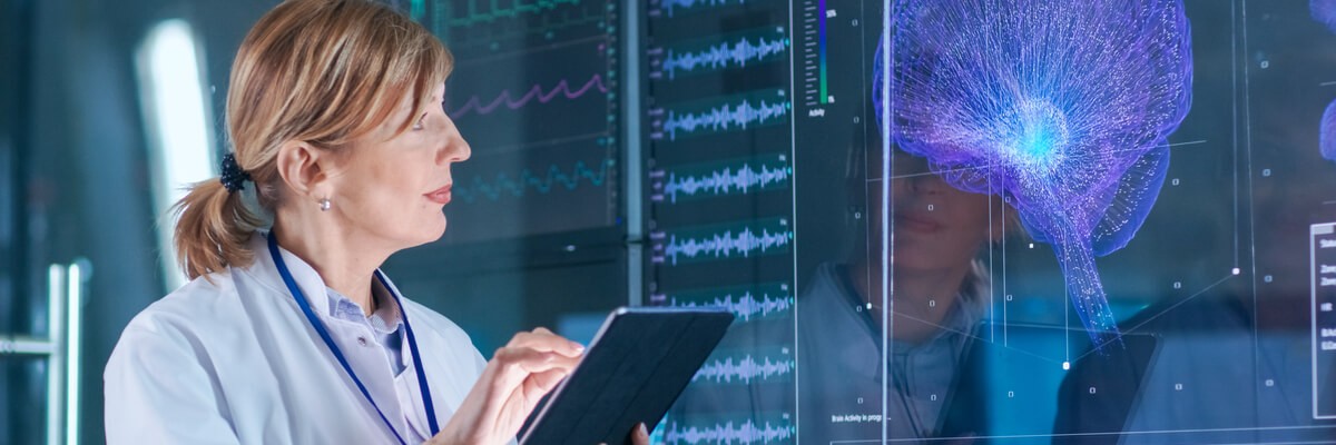 A doctor looking at a screen with an image of a brain.