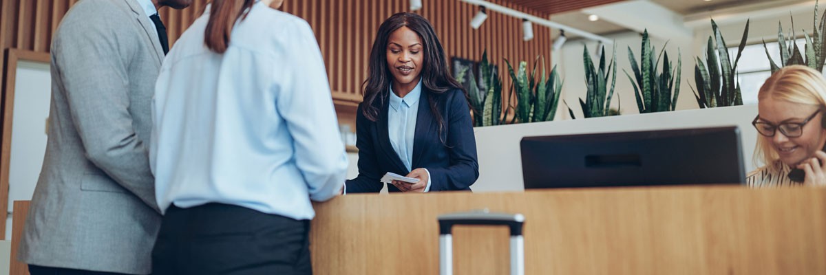 Close up of business people checking in at hotel lobby