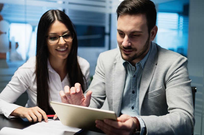 Two business professionals using tablet device