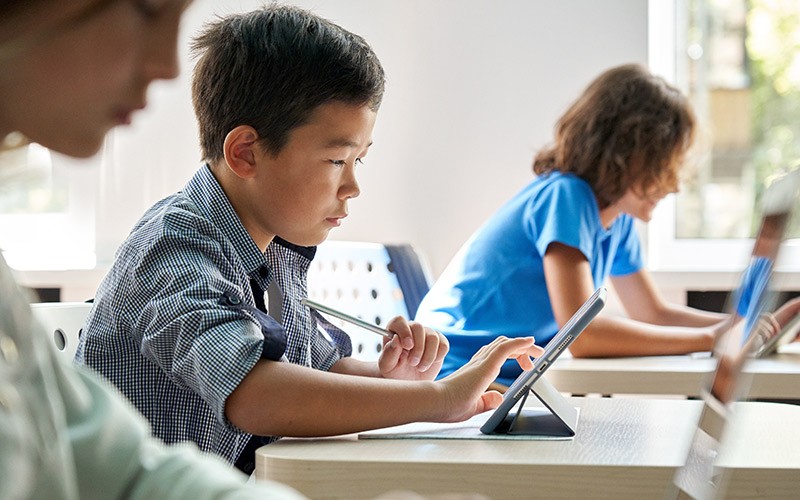 Young student on tablet device in the classroom