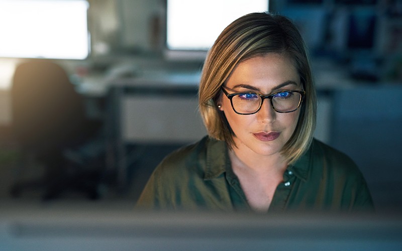 Female IT professional on computer in office at night