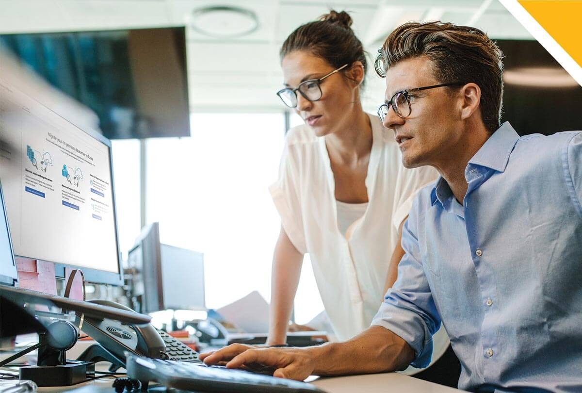 Man and woman review web page on computer desktop