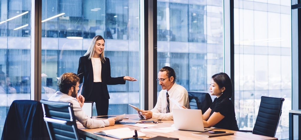 Businessmen and businesswomen review data and information at a team meeting