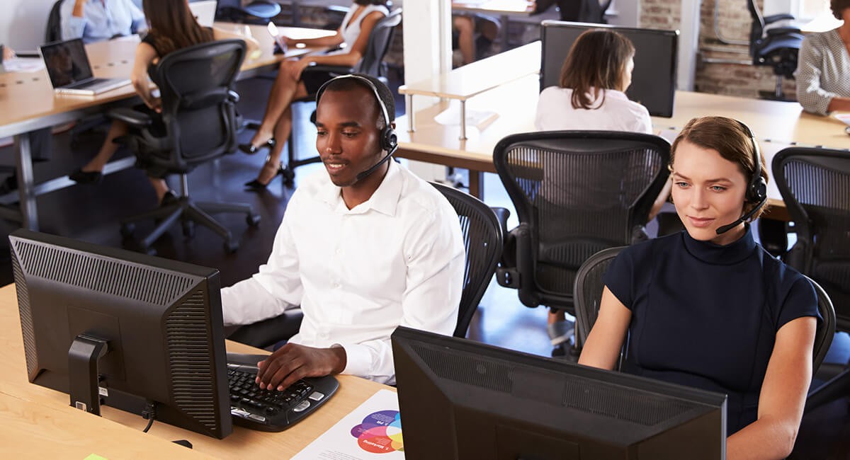 Workers with headsets shown at a contact center