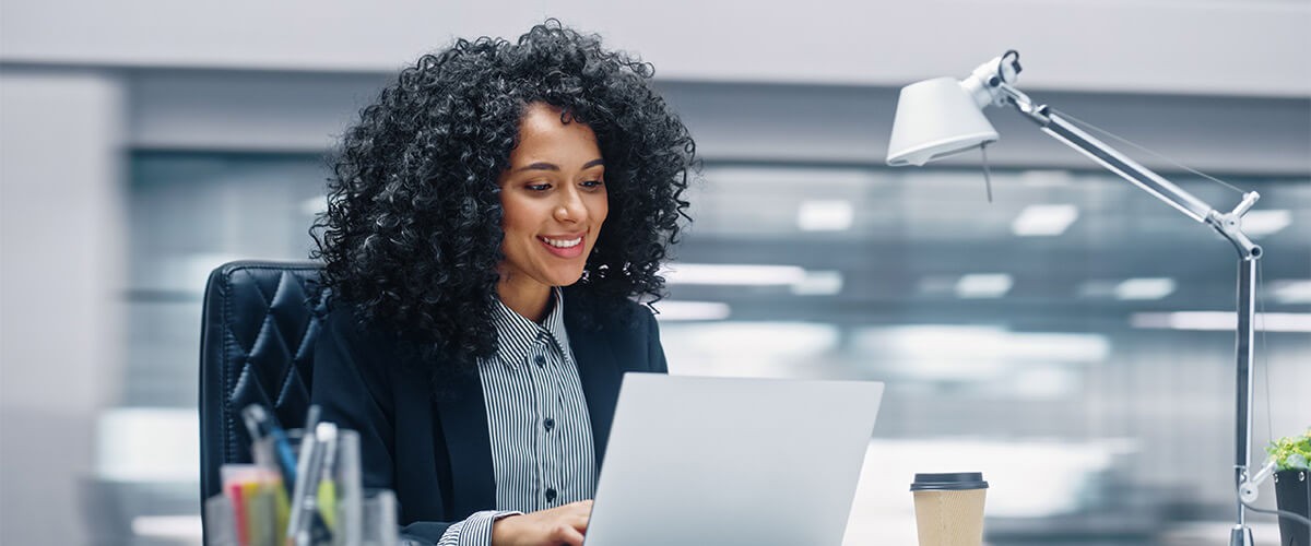 Business woman at desk using laptop computer. Artificial intelligence, computer vision