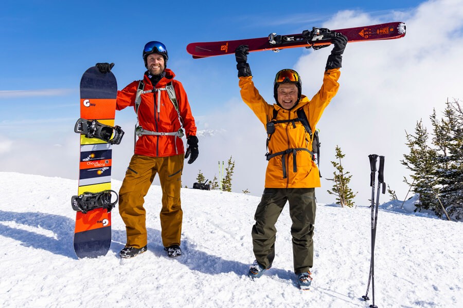 Skiers cheer on top of mountain. 