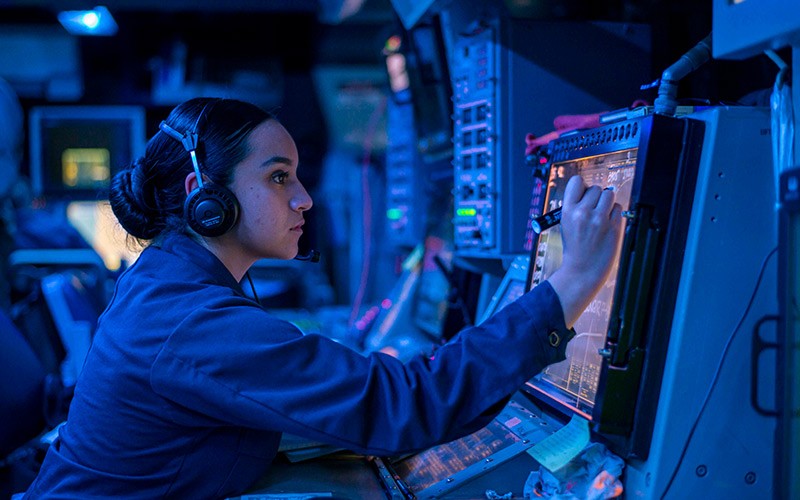 Military member in command center using devices