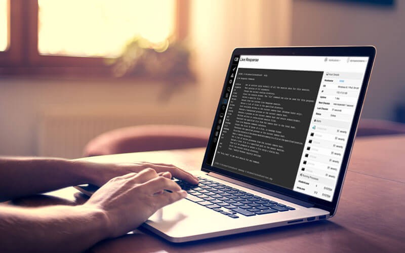 Hands typing on laptop device displaying Carbon Black Response software product