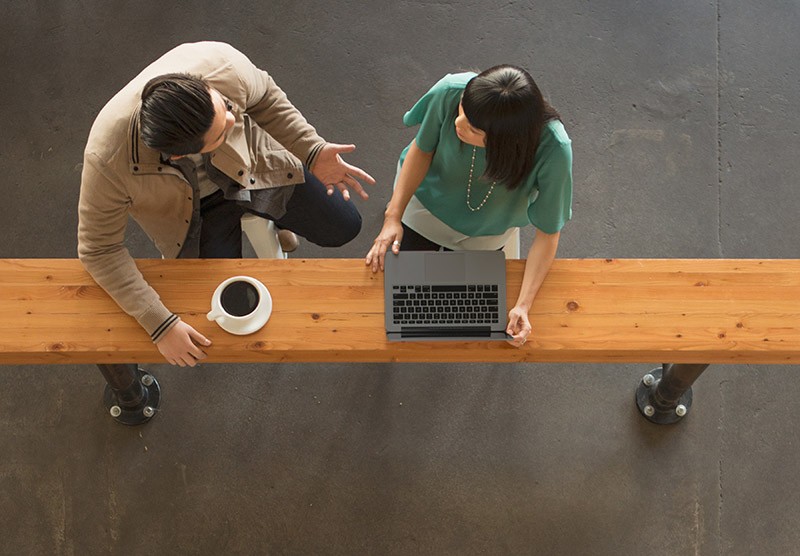 Professionals sharing ideas using laptop