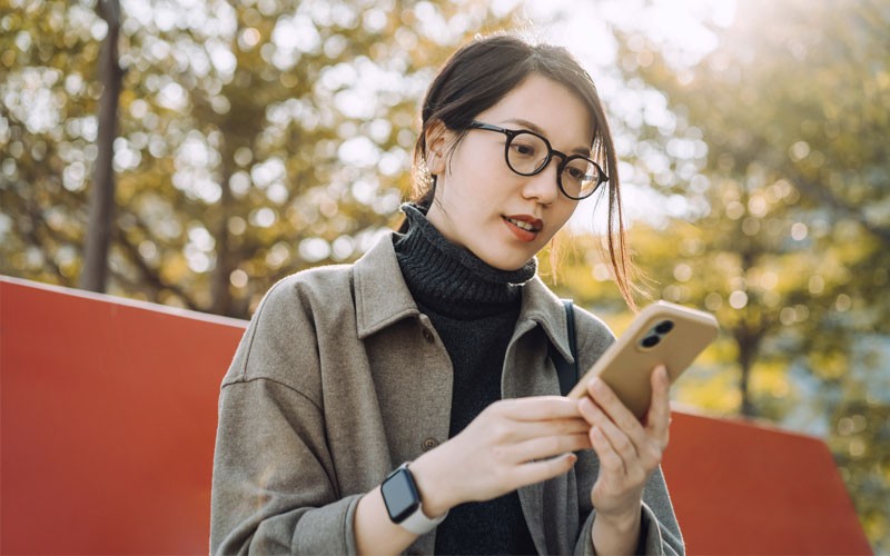 Businesswoman using Cisco collaboration solutions on mobile device outside