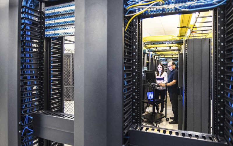 View of IT engineers working together in a sever room