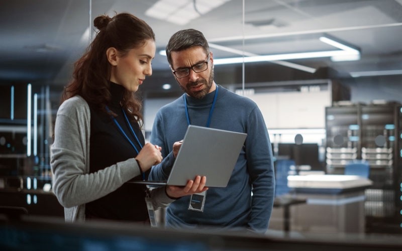 Two IT security engineers looking at laptop device