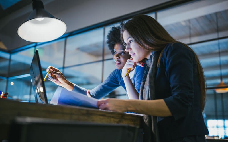 Two woman collaborating using notebook