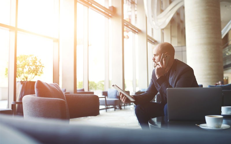 Business man on mobile phone in company lobby