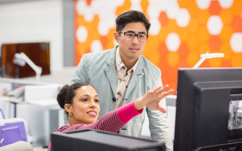 Woman and male discussing over desktop device