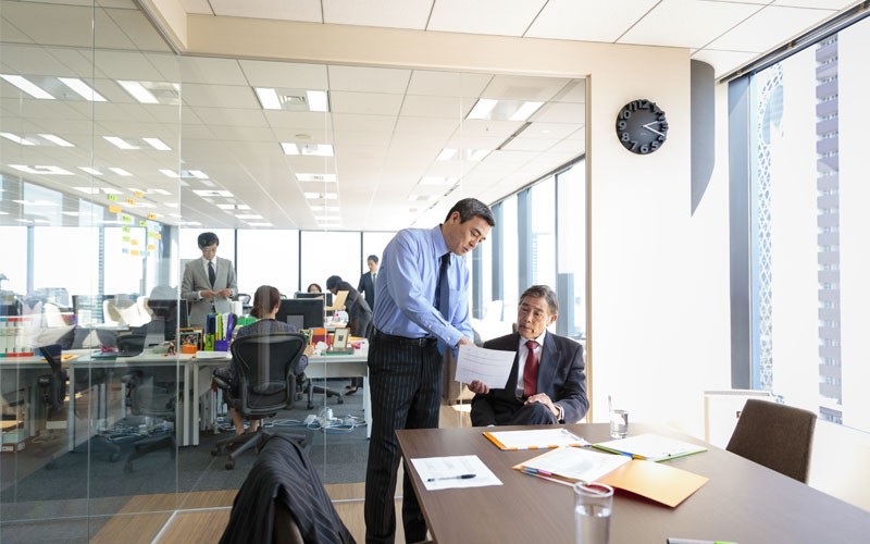 Two men in meeting room discussing