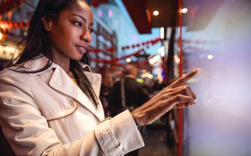 woman touching digital sign