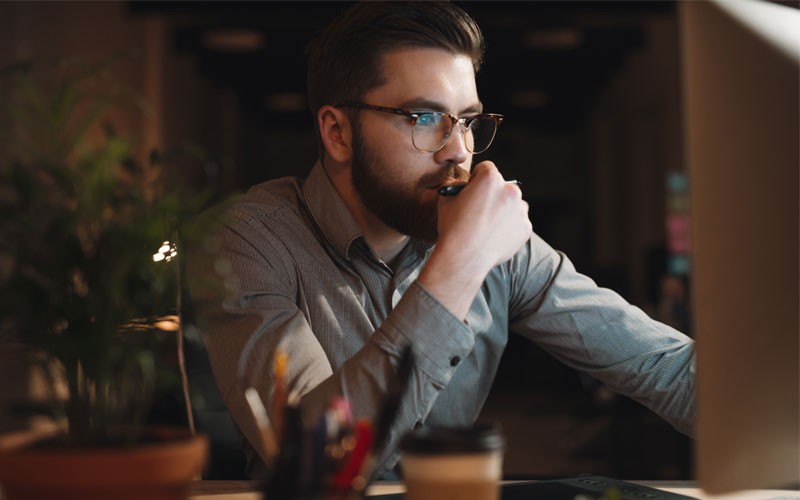 Man working at night at desk in front of desktop